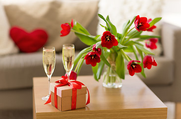 Image showing gift box, champagne glasses and flowers on table