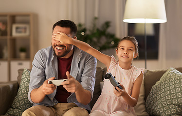 Image showing father and daughter playing video game at home