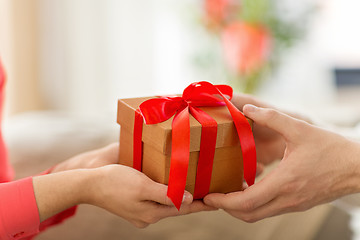 Image showing close up of male and female hands with gift box