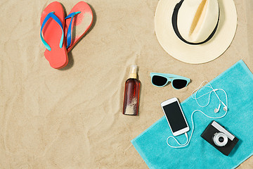 Image showing smartphone, hat, flip flops and shades on beach