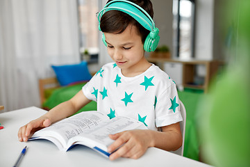 Image showing boy in headphones with textbook learning at home