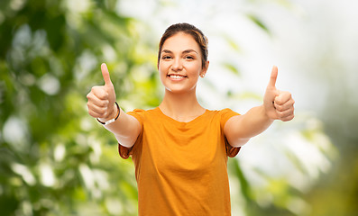 Image showing teen girl showing thumbs up over natural backgdrop