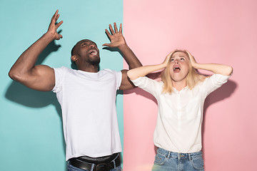 Image showing We won. Winning success happy afro man and woman celebrating being a winner. Dynamic image of caucasian female and male model on pink studio.