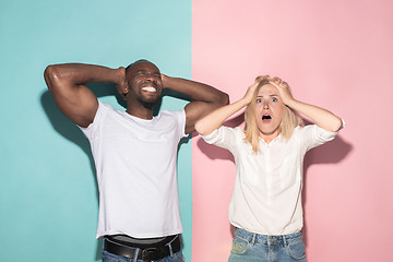 Image showing We won. Winning success happy afro man and woman celebrating being a winner. Dynamic image of caucasian female and male model on pink studio.