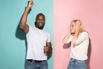 Image showing We won. Winning success happy afro man and woman celebrating being a winner. Dynamic image of caucasian female and male model on pink studio.