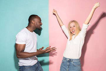 Image showing We won. Winning success happy afro man and woman celebrating being a winner. Dynamic image of caucasian female and male model on pink studio.