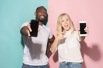 Image showing Portrait of a confident casual girl showing blank screen mobile phone and afro man