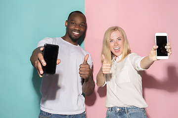 Image showing Portrait of a confident casual girl showing blank screen mobile phone and afro man