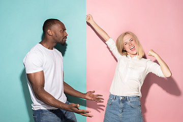 Image showing We won. Winning success happy afro man and woman celebrating being a winner. Dynamic image of caucasian female and male model on pink studio.