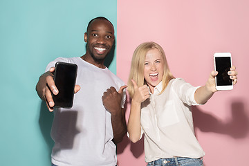 Image showing Portrait of a confident casual girl showing blank screen mobile phone and afro man