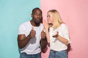 Image showing happy afro man and woman. Dynamic image of caucasian female and afro male model on pink studio.