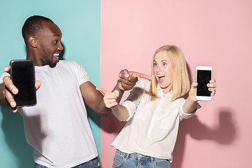 Image showing Portrait of a confident casual girl showing blank screen mobile phone and afro man