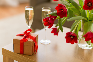 Image showing gift box, champagne glasses and flowers on table