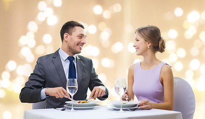 Image showing smiling couple eating appetizers at restaurant