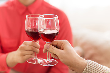 Image showing hands of couple clinking red wine glasses