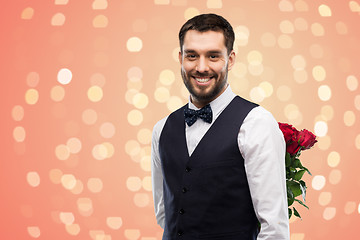 Image showing happy man with red roses behind his back