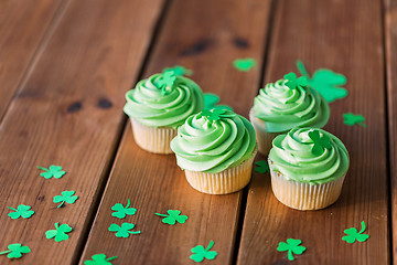 Image showing green cupcakes and shamrock on wooden table