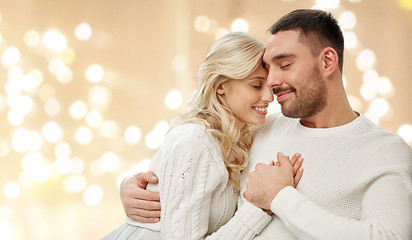 Image showing happy couple hugging over lights on background