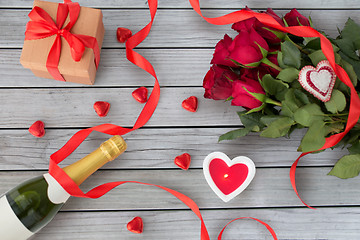 Image showing close up of champagne, gift, candies and red roses