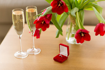 Image showing diamond ring, champagne and flowers on table