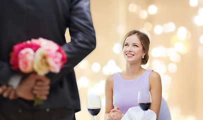 Image showing young woman looking at man with flower bouquet