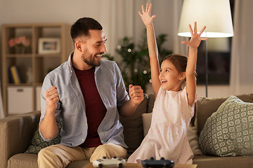 Image showing father and daughter playing video game at home