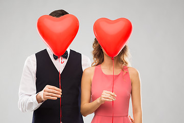 Image showing couple hiding behind red heart shaped balloons