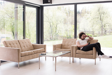 Image showing young man using a mobile phone  at home