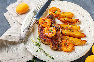 Image showing Juicy pork steak with apricots,thyme and potatoes.