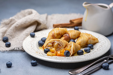 Image showing Crepes with apple filling, blueberry and caramel sauce.