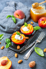 Image showing Fresh grilled peaches with honey and green basil.