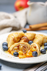 Image showing Homemade crepes with apples and caramel sauce.