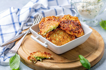 Image showing Zucchini pancakes with sour cream sauce.