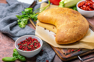 Image showing Homemade pizza calzone on a wooden board.