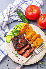 Image showing Steak with pink pepper, rosemary and baked potatoes.