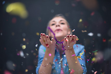 Image showing woman blowing confetti in the air