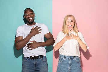 Image showing happy afro man and woman. Dynamic image of caucasian female and afro male model on pink studio.