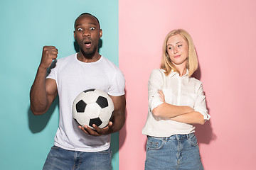 Image showing Closeup portrait of young couple, man, woman. One being excited happy smiling, other serious, concerned, unhappy on pink and blue background. Emotion contrasts