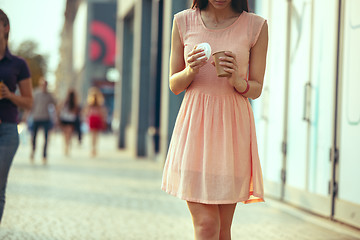 Image showing Beautiful woman holding paper coffee cup and enjoying the walk in the city