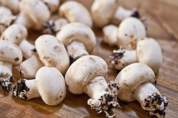 Image showing Fresh raw organic champignons on a wooden table.