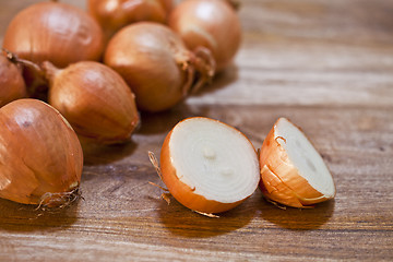 Image showing Organic fresh  onions heap closeup on rustic wooden table backgr