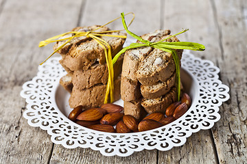 Image showing Almond seeds and fresh Italian cookies cantuccini stacked on whi