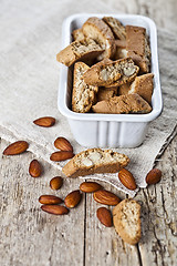 Image showing Cookies cantuccini in white ceramic bowl and almond seeds on lin