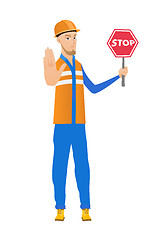 Image showing Young caucasian builder holding stop road sign.