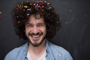 Image showing man blowing confetti in the air