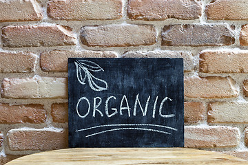 Image showing Chalk board with the word ORGANIC drown by hand and chalks on wo