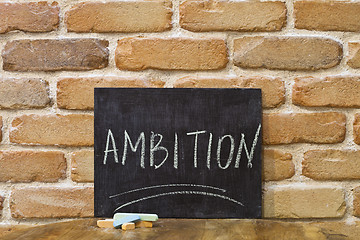 Image showing Chalk board with the word AMBITION drown by hand and chalks on w