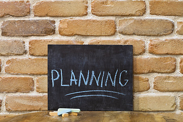 Image showing Chalk board with the word PLANNING drown by hand and chalks on w