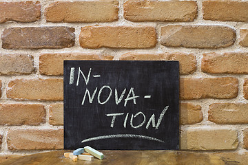 Image showing Chalk board with the word INNOVATION drown by hand and chalks on