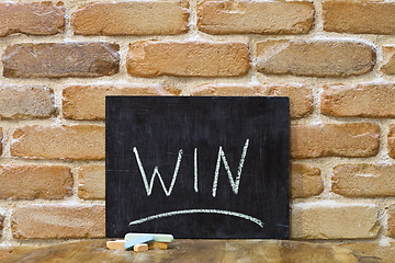 Image showing Chalk board with the word WIN drown by hand and chalks on wooden